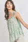 Top sin mangas con peplum fruncido y detalle de volantes