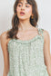 Top sin mangas con peplum fruncido y detalle de volantes
