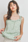 Top sin mangas con peplum fruncido y detalle de volantes